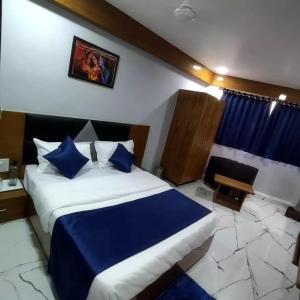 a bedroom with a large bed and a table and a window at HOTEL SHREE RADHE in Ahmedabad