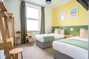 a hotel room with two beds and a window at Tregarthen's Hotel in Hugh Town