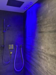 uma casa de banho com um chuveiro com iluminação azul em Pezza 21 em Samnaun
