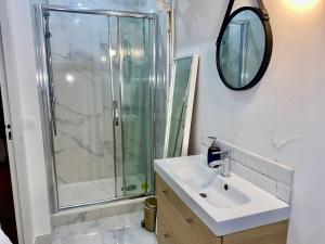 a bathroom with a shower and a sink and a mirror at Michel Ange - Cosy appartement de 8P in Paris