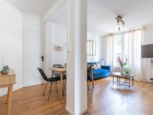 ein Wohnzimmer mit einem Tisch und einem blauen Sofa in der Unterkunft Michel Ange - Cosy appartement de 8P in Paris