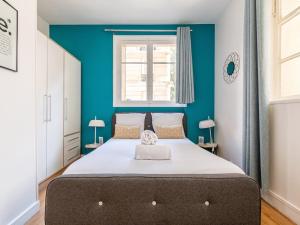 1 dormitorio con 1 cama grande y pared azul en Michel Ange - Cosy appartement de 8P en París