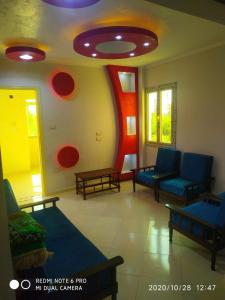 uma sala de estar com cadeiras azuis e círculos vermelhos na parede em قرية النورس مكتب السعد em Ismaília