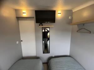 een kleine kamer met 2 bedden en een flatscreen-tv bij Sun House III - Near Sintra - Kitchen - Pool in Mem Martins
