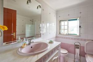 uma casa de banho com um lavatório, um WC e um espelho. em Sun House III - Near Sintra - Kitchen - Pool em Mem Martins
