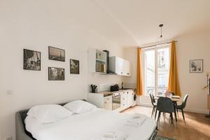 sypialnia z łóżkiem i stołem oraz kuchnia w obiekcie Charmant appartement proche Opéra Garnier - 4p w Paryżu