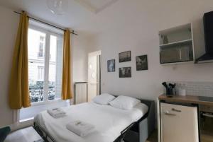 Kleines Zimmer mit einem Bett und einem Fenster in der Unterkunft Charmant appartement proche Opéra Garnier - 4p in Paris