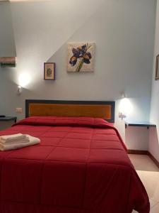 1 dormitorio con cama roja y manta roja en Lattrazionedelgeco, en Terni