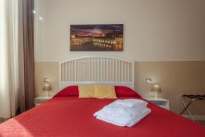 ボローニャにあるIl Tiro Roomsのベッドルーム1室(赤いベッド1台、タオル付)