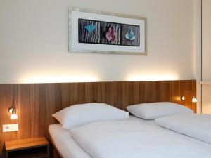 a bedroom with two beds and a picture on the wall at B&B HOTEL Berlin-Mitte in Berlin