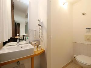 a white bathroom with a sink and a toilet at B&B HOTEL Berlin-Mitte in Berlin
