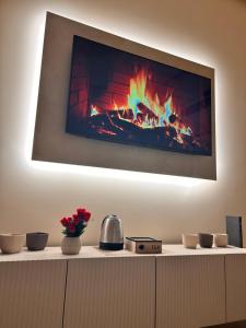 a tv hanging on a wall with a fireplace at Mael Superior Room in Palermo