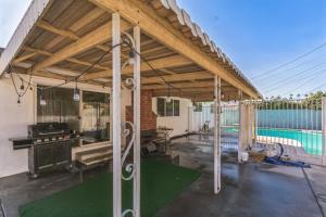 a covered patio with a grill and a pool at Modern Relaxing Retreat with Private Pool home in Azusa