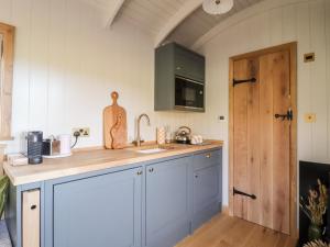 a kitchen with a sink and a wooden door at Shepherd Hut 2 in Harrogate