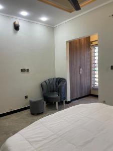 - une chambre avec un lit, une chaise et une porte dans l'établissement BAHRIA HOLLIDAY HOME 2, à Rawalpindi