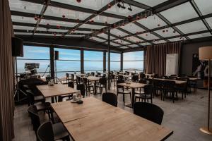 um restaurante com mesas e cadeiras e janelas grandes em DARIC HOTELS em Atakum
