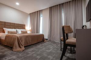 a hotel room with a bed and a chair at DARIC HOTELS in Atakum