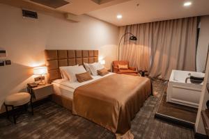 een hotelkamer met een groot bed en een stoel bij DARIC HOTELS in Atakum