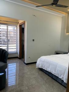 - une chambre avec un lit, une chaise et une fenêtre dans l'établissement BAHRIA HOLLIDAY HOME 2, à Rawalpindi