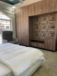 - une chambre avec un grand lit et une chaise dans l'établissement BAHRIA HOLLIDAY HOME 2, à Rawalpindi
