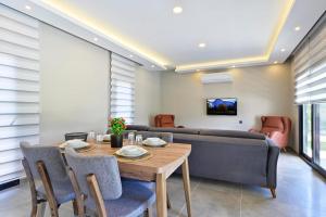 uma sala de estar com uma mesa e um sofá em MERA-12 FETHİYE KARGI HAVUZLU VİLLALARIMIZ em Fethiye
