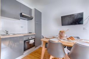 a kitchen with a wooden table with chairs and a sink at Appartement near to Saint Lazare - 6P in Paris