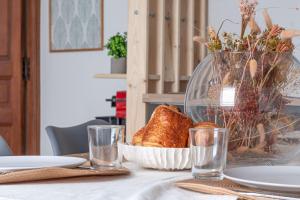 a table with a bowl of bread and a vase at Appartement near to Saint Lazare - 6P in Paris