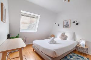 a bedroom with a white bed and a window at Appartement near to Saint Lazare - 6P in Paris