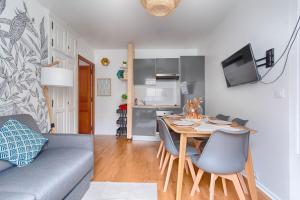 a living room with a table and a couch at Appartement near to Saint Lazare - 6P in Paris