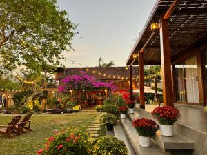 a garden with potted plants and flowers on a building at Hapu Garden homestay in Buôn Enao