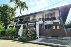 ein Haus mit einem Zaun davor in der Unterkunft Spacious Spanish-Style Resort in Pansol Laguna in Calamba