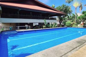 einem großen blauen Pool vor einem Gebäude in der Unterkunft Spacious Spanish-Style Resort in Pansol Laguna in Calamba