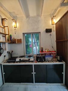une cuisine avec un comptoir avec une cuisinière et une fenêtre dans l'établissement Private Villa by Rashuthere, à Rasdhoo