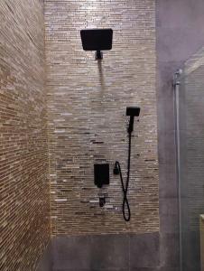 a brick wall with a shower and a phone at Secret Villa by Rashuthere in Rasdu