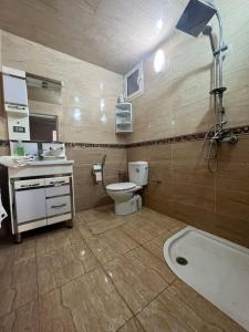 a bathroom with a toilet and a sink and a tub at Luxury suite in Ben Slimane