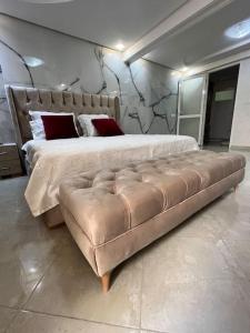 a bedroom with a large bed and a leather couch at Luxury suite in Ben Slimane