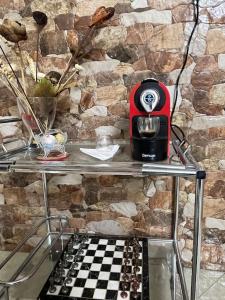 a table with a coffee maker on a stone wall at Luxury suite in Ben Slimane