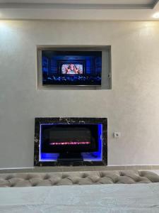 a living room with a tv and a fireplace at Luxury suite in Ben Slimane