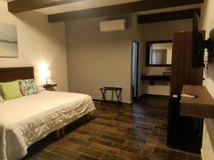Habitación de hotel con cama y espejo en Hacienda Viga 2020 Hotel, en Cuatrociénegas de Carranza