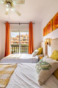 two beds in a room with a window at Casares del Sol Apartment in Casares