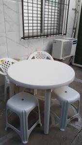 una mesa blanca y dos taburetes en una habitación en Beach House en Salinas da Margarida
