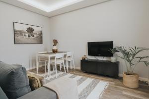 - un salon avec une télévision et une table dans l'établissement Pico Apartment's, à Câmara de Lobos