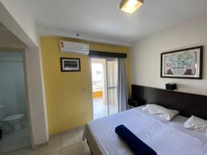 a bedroom with a large bed and a yellow wall at Flat Amplo em frente USP/FOB in Bauru