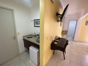 a bathroom with a sink and a chair in a room at Flat Amplo em frente USP/FOB in Bauru