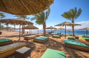 a beach with chairs and umbrellas and the ocean at Al Riyahi Cabanas in Al Burj