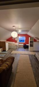 Kamchanod Resort Haukipudas Oulu في أولو: غرفة معيشة مع أريكة وجدار احمر