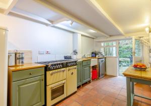 a large kitchen with green appliances in a room at Ball Cottage in Little Petherick