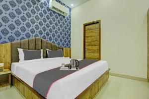 una camera con un letto e un telefono su un vassoio di Collection O Rd Hotel a Zirakpur