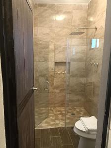 y baño con ducha de cristal y aseo. en Hacienda Viga 2020 Hotel, en Cuatrociénegas de Carranza