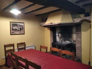 comedor con mesa y chimenea en Casa la Cisterna, en Pina de Montolgrao